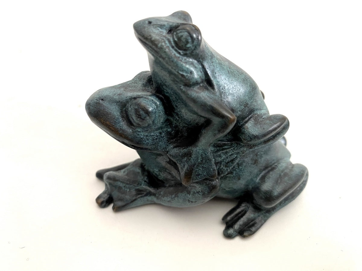 Froschgruppe aus Bronze mit grüner Patina in schräger Vorderansicht vor hellem Hintergrund