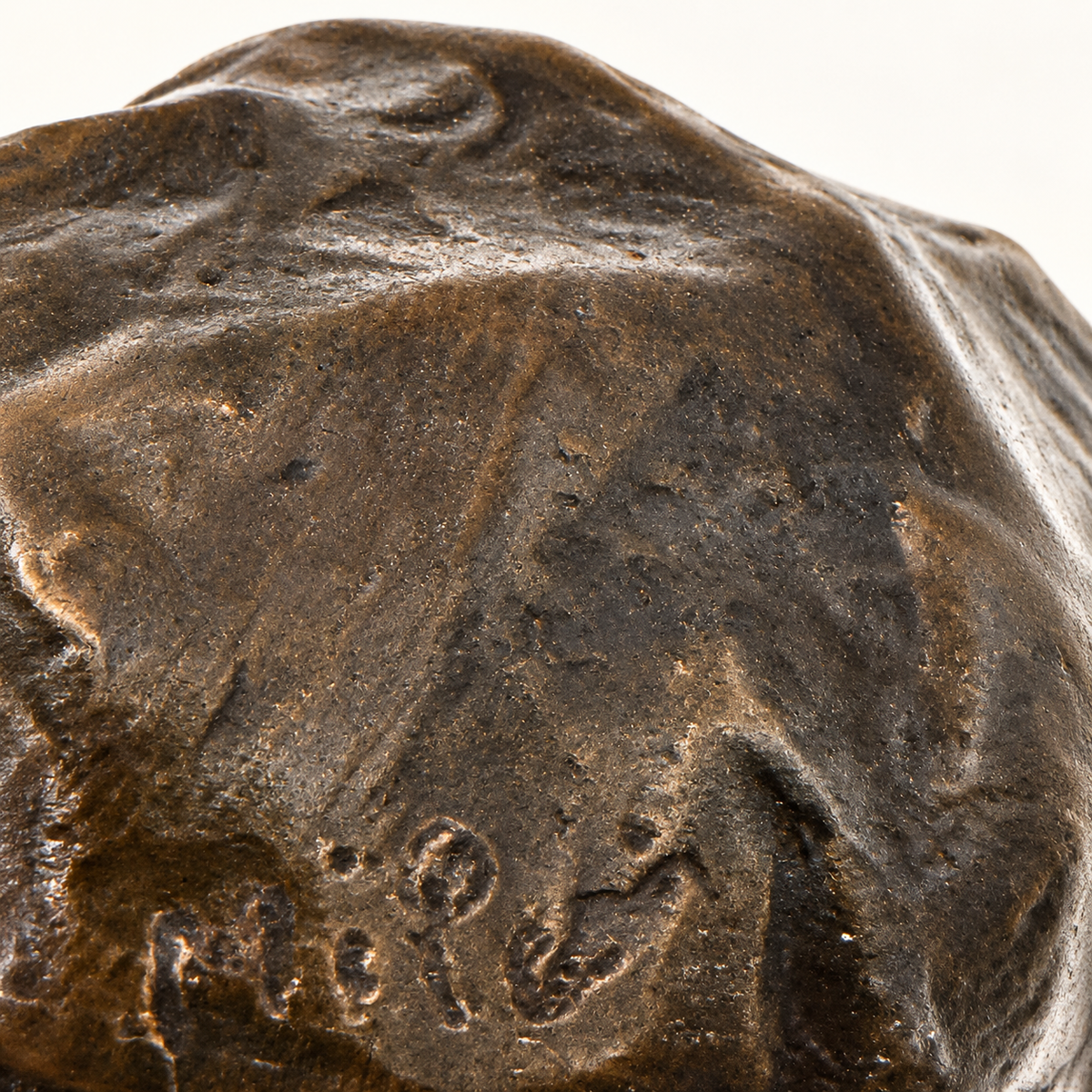 Nahaufnahme der Signatur und Oberflächenstruktur der liegenden Nashorn-Skulptur aus Bronze
