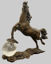 Bronzefigur Pferd auf transparenter Glaskugel – schräg frontale Ansicht