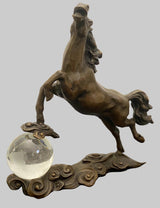 teigendes Pferd aus Bronze mit Glaskugel – schräg seitliche Ansicht