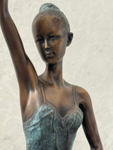 Detailaufnahme von Gesicht, Arm und Oberkörper der Bronze-Ballerina in grün patiniertem Ballettkleid.
