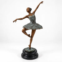 Ganzansicht der Bronze-Ballerina nach Edgar Degas mit ausgreifender Armhaltung auf rundem schwarzem Marmorsockel.