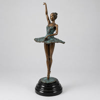 Bronze-Ballerina nach Edgar Degas mit erhobenem Arm und grün patiniertem Tutu auf schwarzem Marmorsockel.
