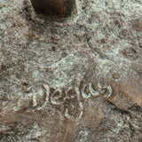 Nahaufnahme des Schriftzugs „Degas“ auf der strukturierten, grünlich patinierten Bronzeplatte der Ballerina.