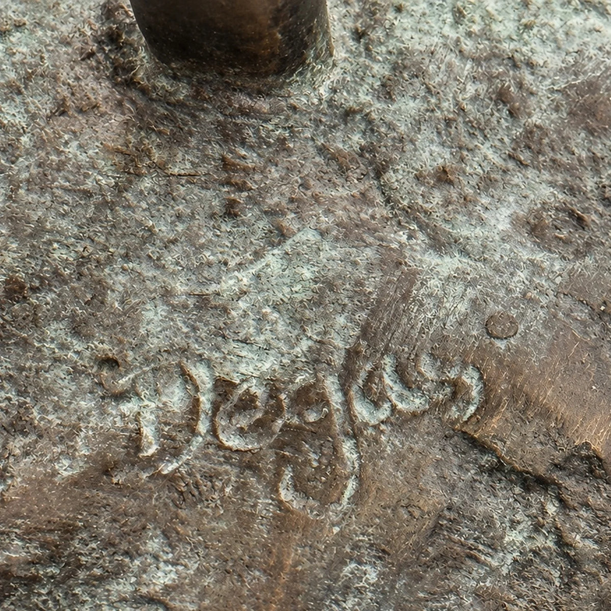 Nahaufnahme des Schriftzugs „Degas“ auf der strukturierten, grünlich patinierten Bronzeplatte der Ballerina.