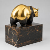 Bronzebär auf Marmorsockel aus rückwärtiger Schrägansicht.