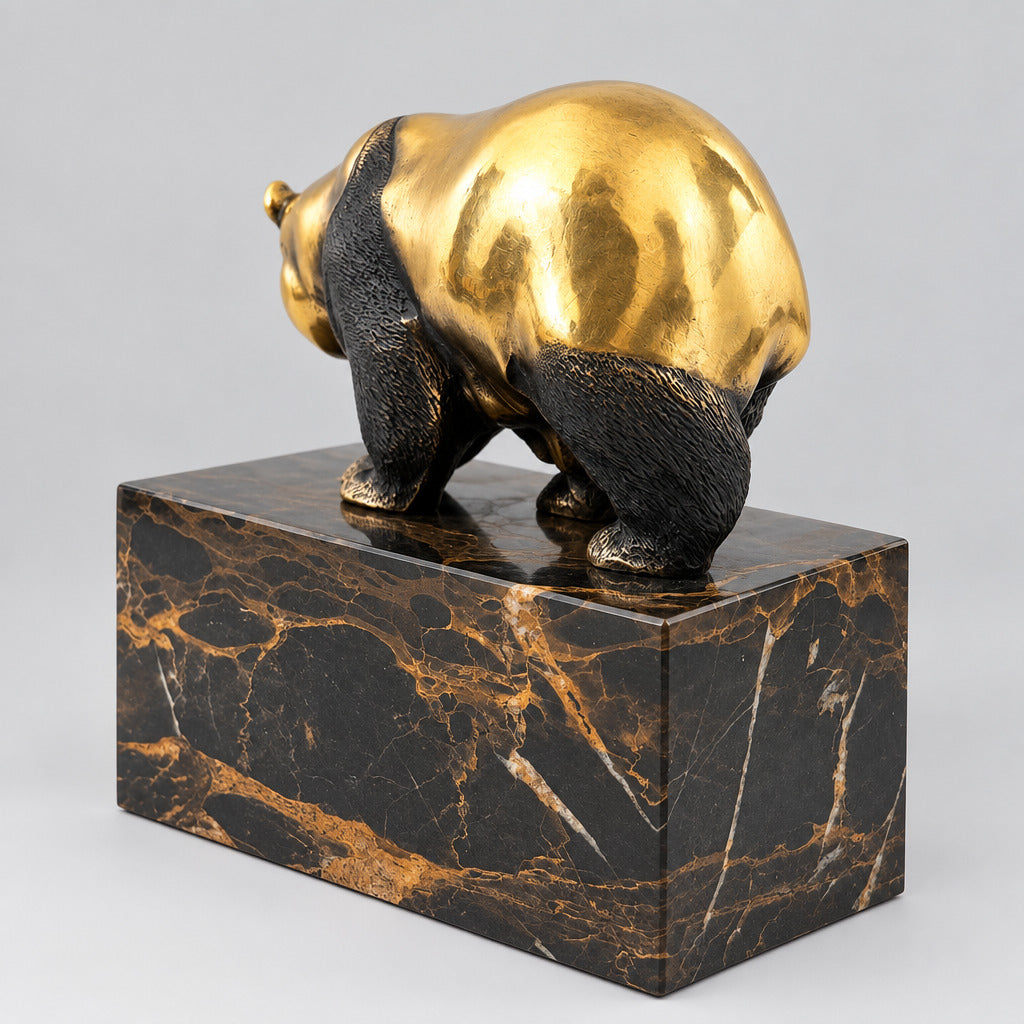 Bronzebär auf dem dunkel marmorierten Sockel in rückwärtiger Schrägansicht.