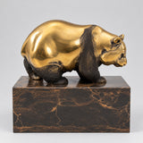 Goldbrauner Bronzebär auf Marmorsockel in seitlicher Ansicht.