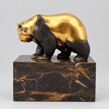 Goldbraun patinierter Bronzebär auf Marmorsockel in linker Seitenansicht.
