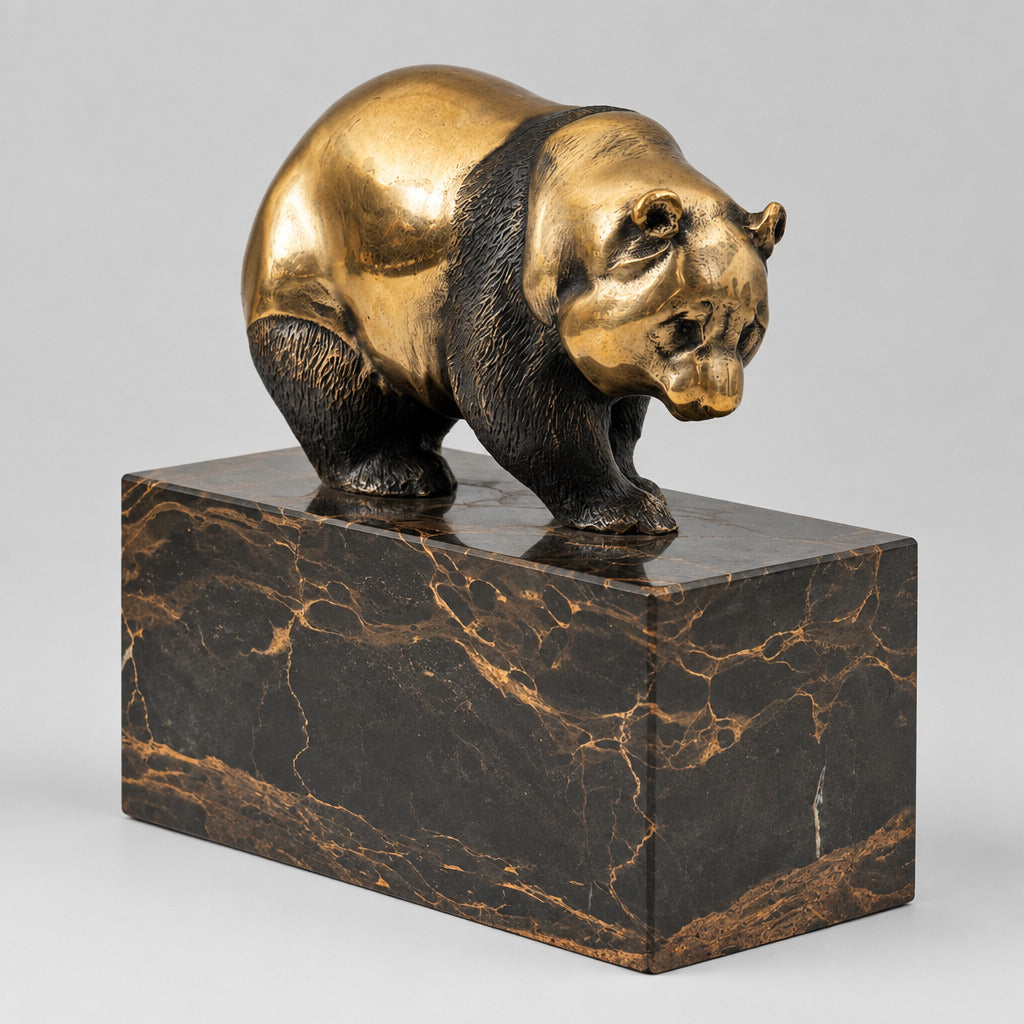 Goldbraun patinierte Bronzefigur eines Bären auf einem dunkel marmorierten Sockel in leichter Vorderansicht.