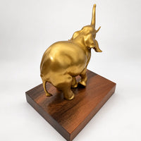 Rückansicht des goldfarbenen Bronze-Elefanten mit Blick auf Rücken, Hinterbeine und Schwanz.