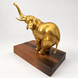 Rückwärtige Schrägansicht der Elefantenfigur aus Bronze mit seitlichem Blick auf Kopf und erhobenen Rüssel.