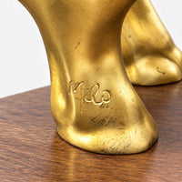 Detailaufnahme der Signatur am Fuß der goldfarbenen Elefantenfigur auf dem braunen Sockel.