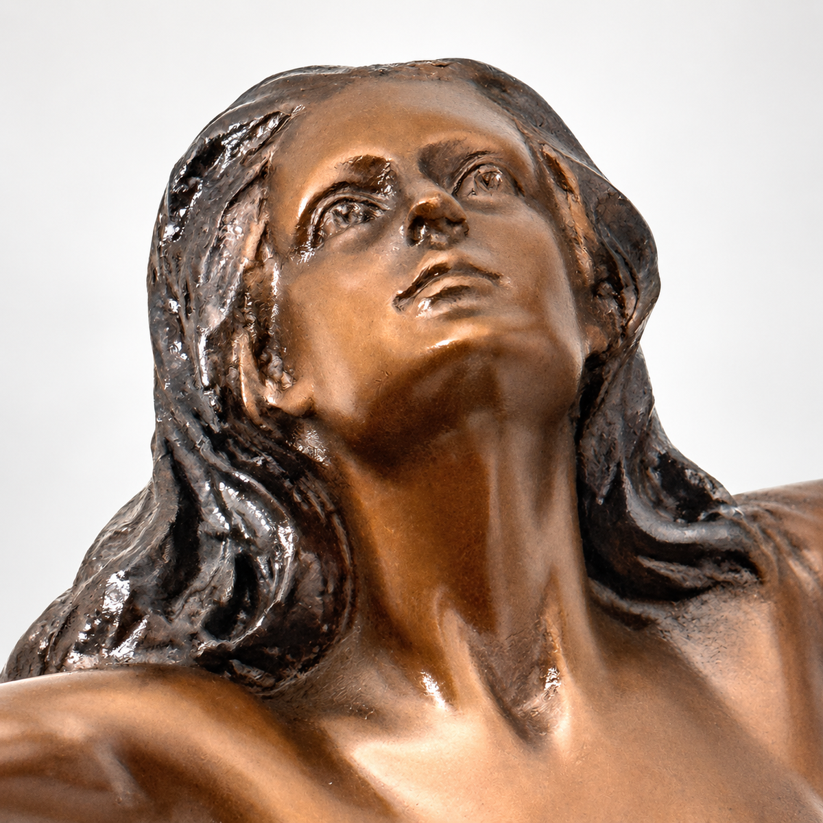 Nahaufnahme des nach oben gerichteten Gesichts und der ausgearbeiteten Haare der Bronzefigur von Raymondo.
