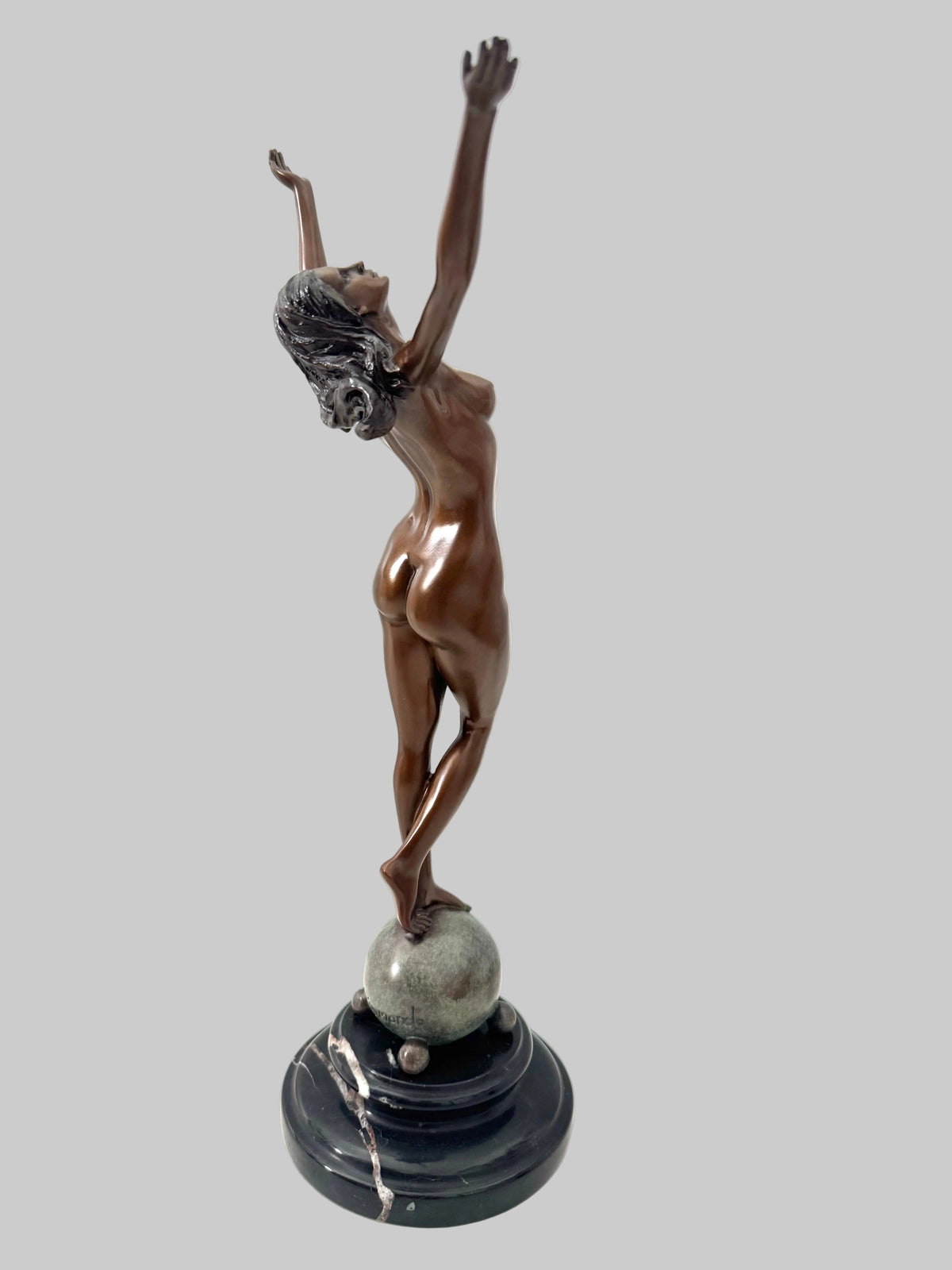 Seitliche Ansicht der Akt-Skulptur von Raymondo mit klassischer Bronzepatina auf Kugel und schwarzem Marmorsockel.