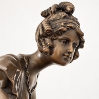 Seitliche Nahaufnahme des geneigten Kopfes der bronzenen Tänzerin mit kunstvoller Hochsteckfrisur.
