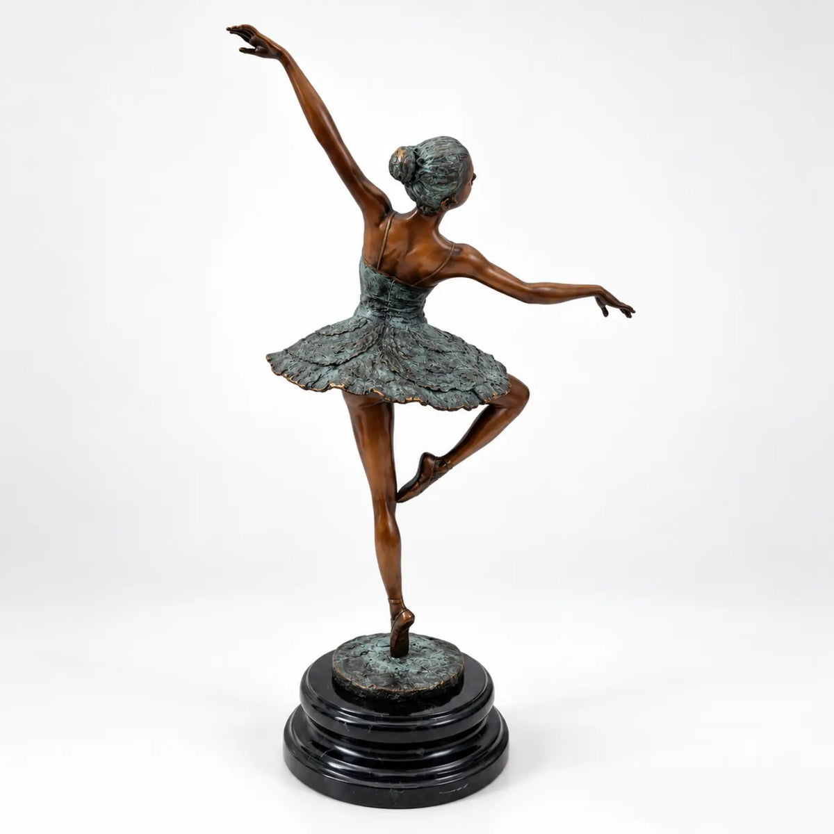 Rückansicht der Bronze-Ballerina mit hochgestecktem Haar, erhobenem Arm und ausgestelltem Tutu auf Marmorsockel.