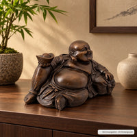 Liegender lachender Buddha aus Bronze als KI-unterstütztes Stimmungsbild in einem stilvollen Wohnambiente