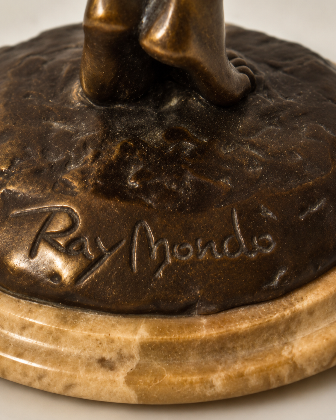 Signatur Raymondo auf der Bronzeplinthe – Detailaufnahme der Bronzeskulptur