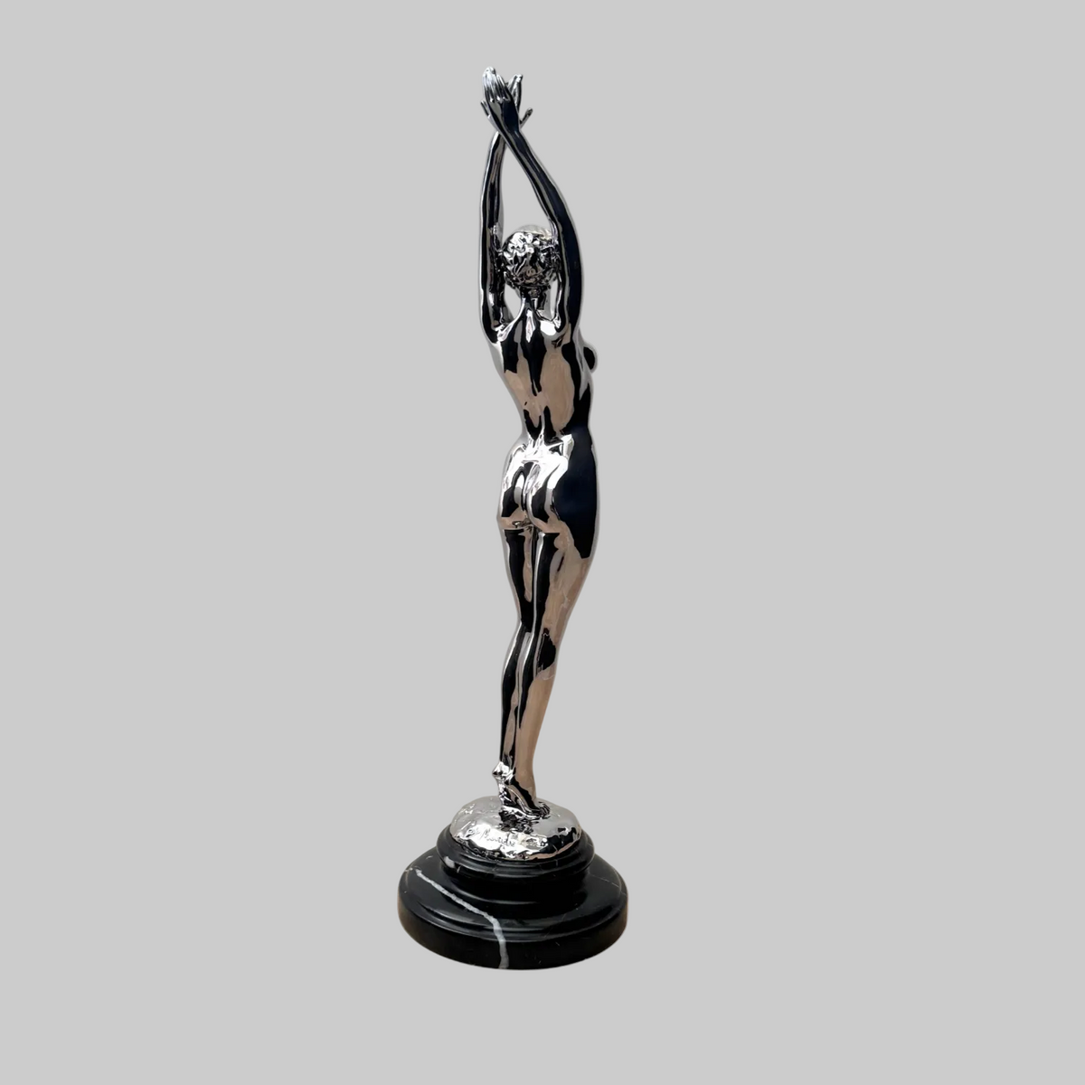 Signierte Raymondo Bronzefigur, verchromter weiblicher Akt mit über dem Kopf erhobenen Armen, aus rückseitiger Perspektive.