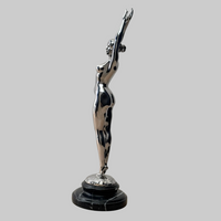 Raymondo Bronzeskulptur mit glänzender Chromoberfläche, seitliche Gesamtansicht des stehenden Frauenakts auf Marmorsockel.